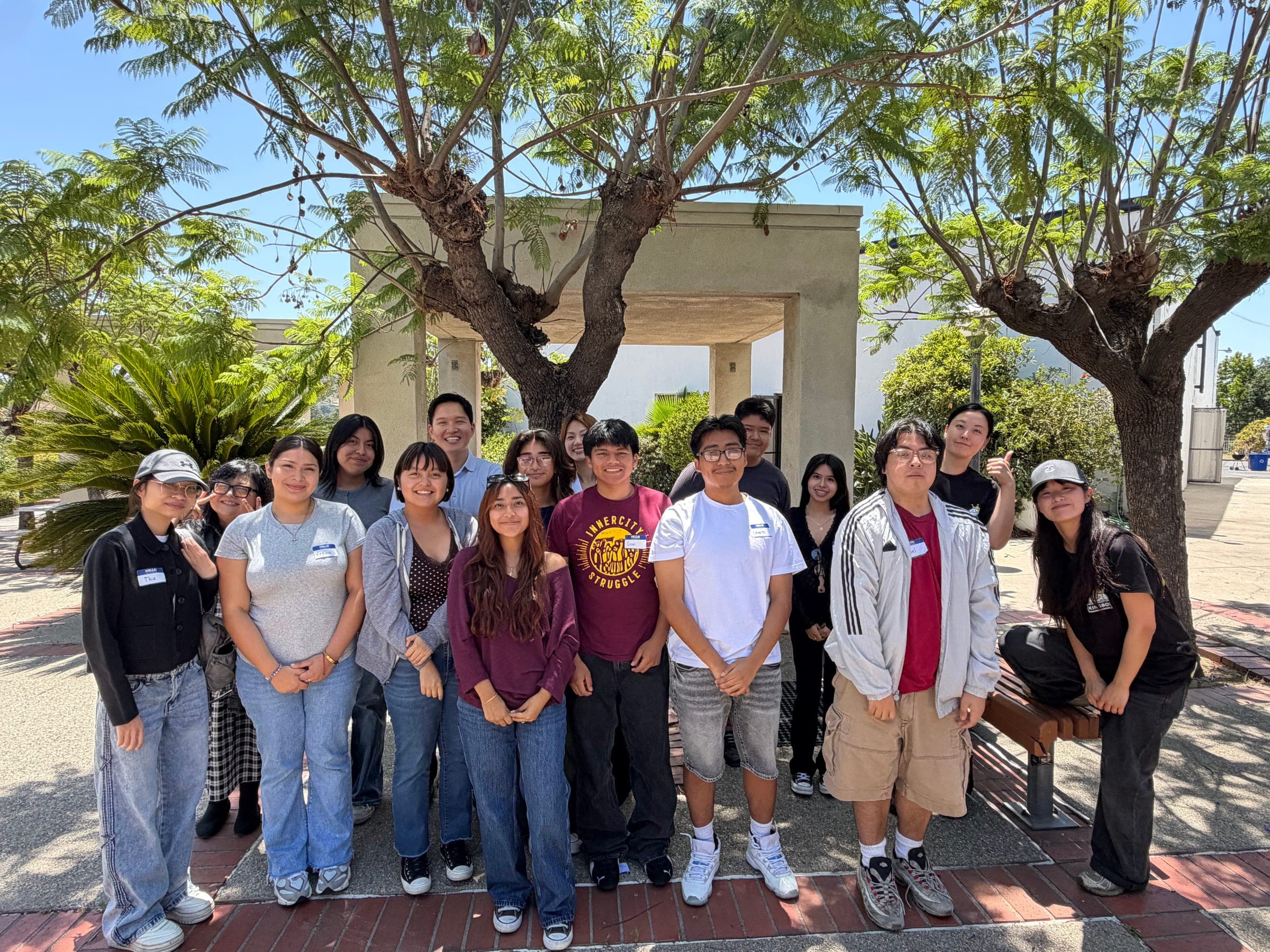A group of Mentor For Change youth and mentors smiling together on a college campus