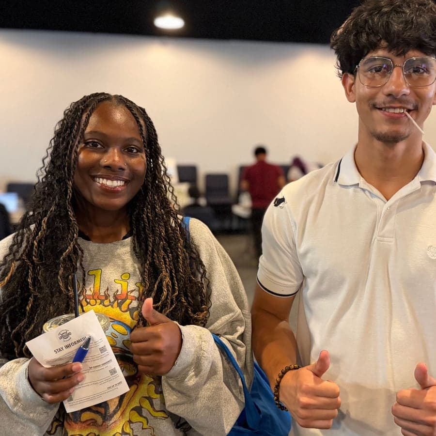 Two youth giving a thumbs up at a program event