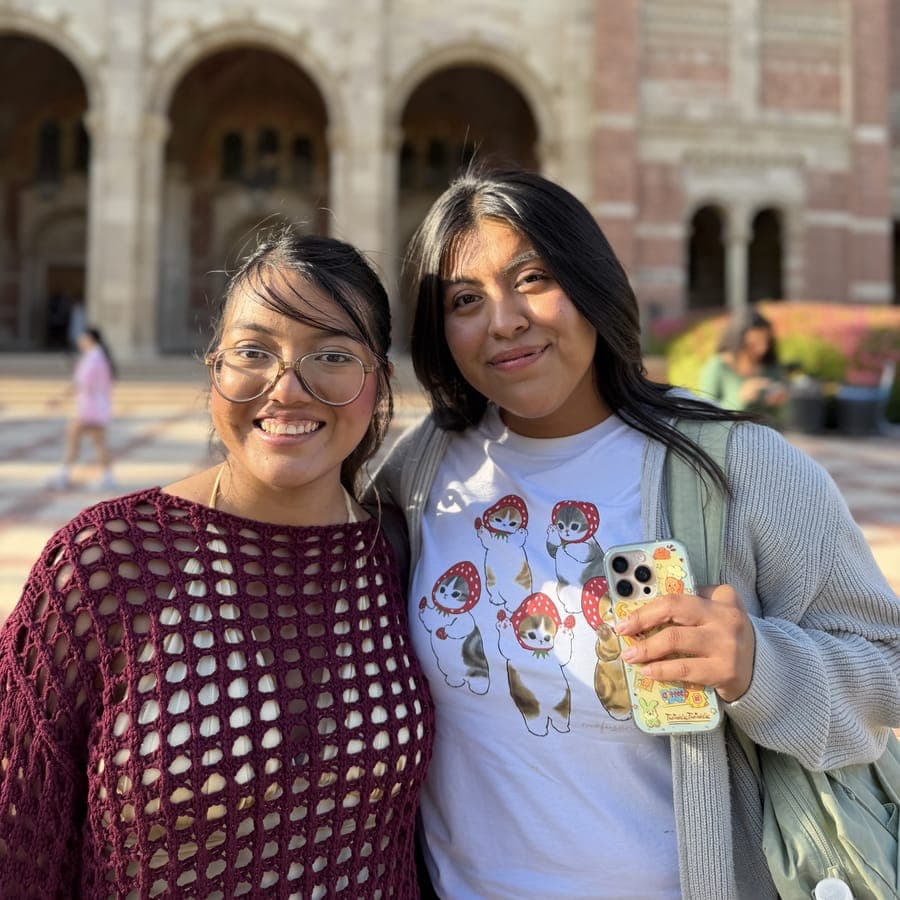 Two women smiling in front of UCLA's Royce Hall